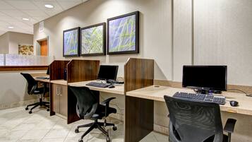 Un espacio de oficina moderno con cubículos, sillas ergonómicas y monitores duales.