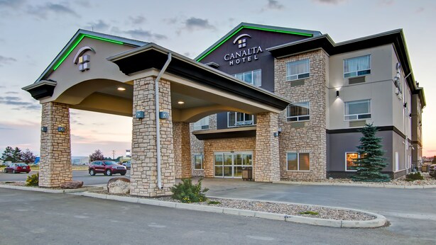 A hotel with a stone facade, a green roof, and a sign reading "CANALTA HOTEL".