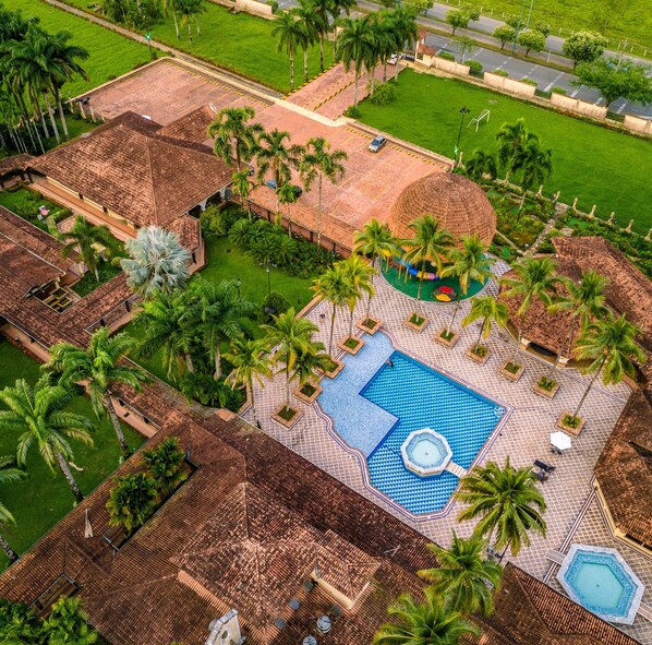 An aerial view of a resort with a swimming pool, palm trees, and a gazebo. - Tequendama Hotel Campestre Villavicencio (Villavicencio)