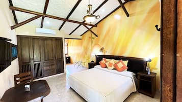 A bedroom with a bed, bedside tables, a wardrobe, and a ceiling fan.