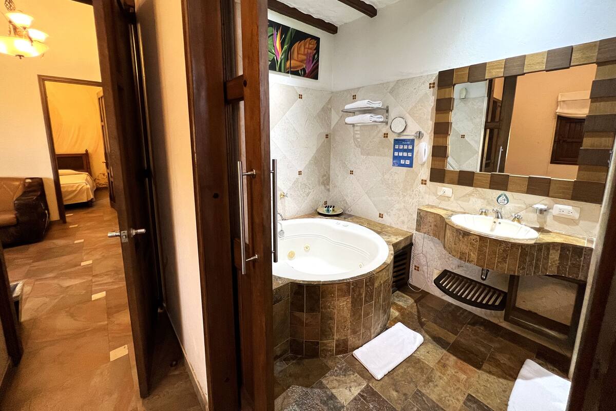 A bathroom with two sinks, a bathtub, and a shower.