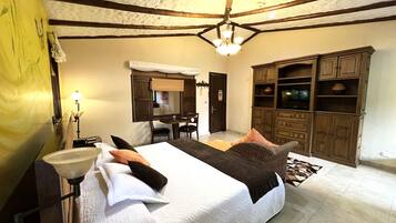 A bedroom with a large bed, a desk, and a wardrobe.