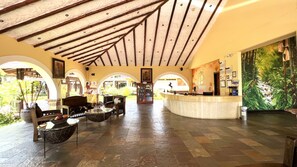 A spacious lobby with a high ceiling, a reception desk, and a mural of a tropical scene. - Tequendama Hotel Campestre Villavicencio (Villavicencio)