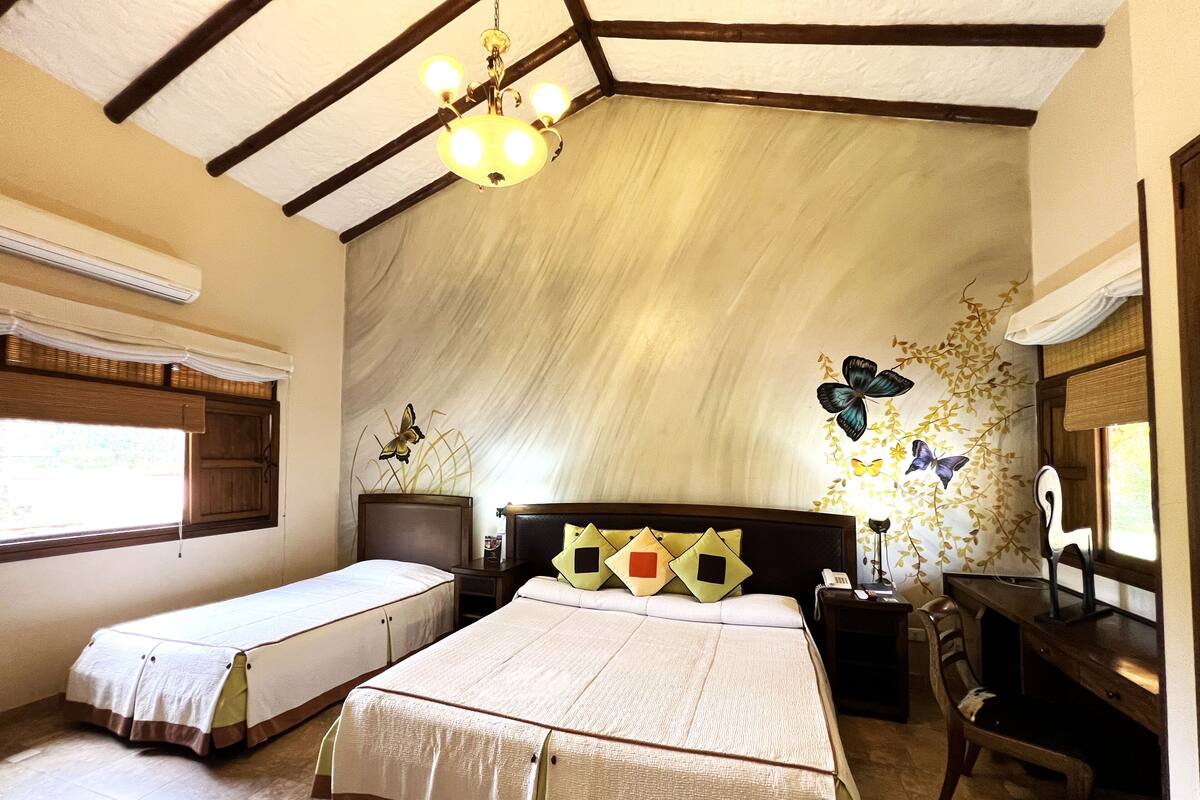A bedroom with two single beds, a desk, and a chair.