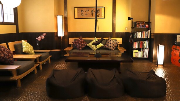 A traditional Japanese-style room with tatami flooring, a low wooden table, and cushions on a sofa.
