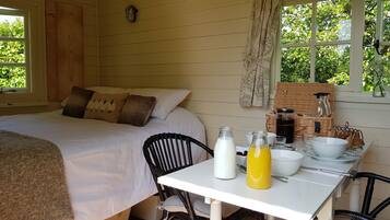 Una habitación acogedora con una cama, una mesa con alimentos para el desayuno y vistas al exterior.