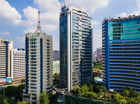 A modern urban skyline with high-rise buildings, including a hotel with a prominent vertical sign.