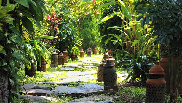 A garden pathway with stone slabs and traditional clay pots.