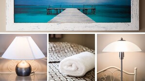 A framed beach scene, a table lamp, a rolled towel, and a floor lamp. - Dockside Mooloolaba (Mooloolaba)