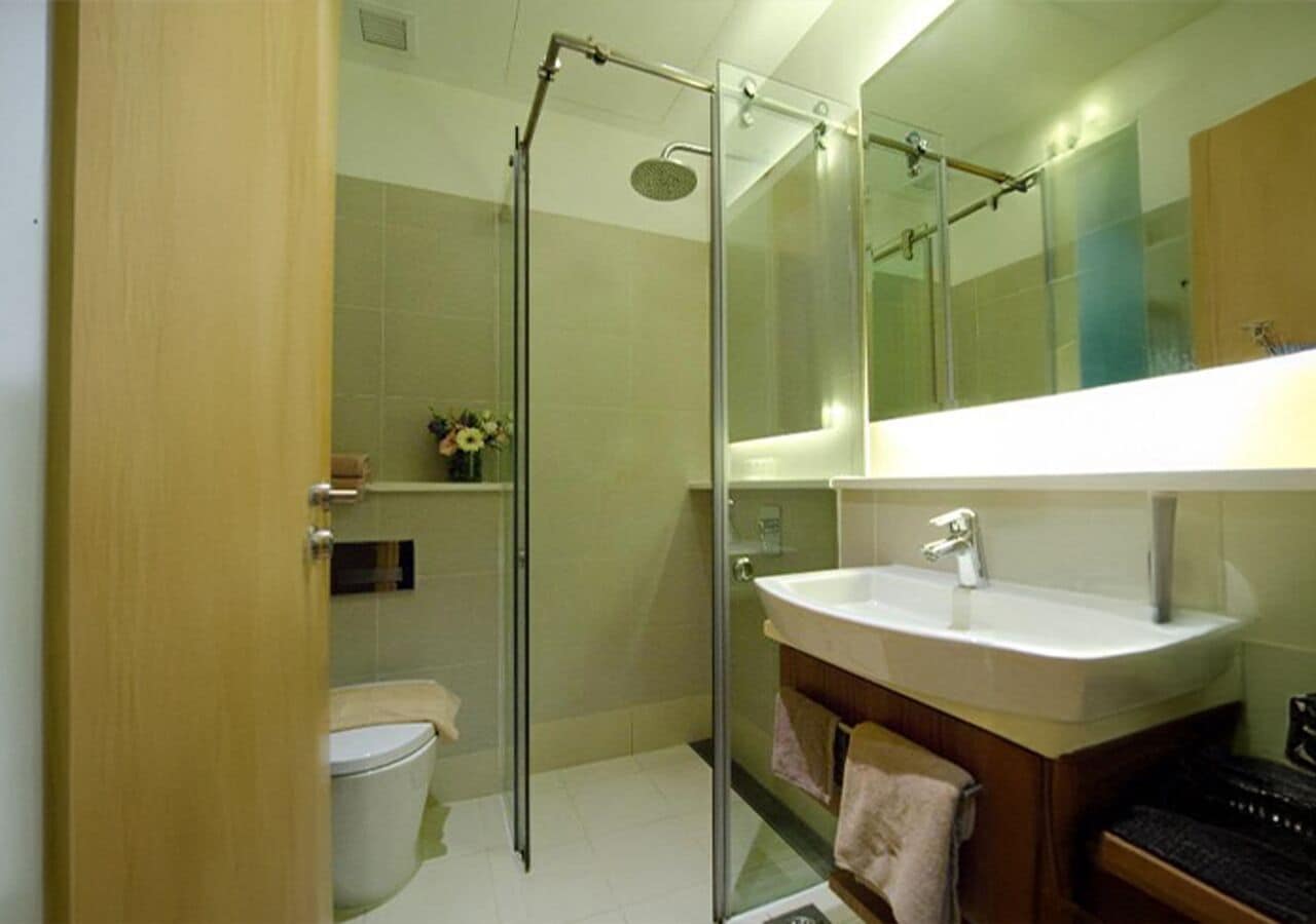 Ein modernes Badezimmer mit einer Glasdusche, einem weißen Waschbecken und einer Toilette.