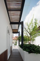 A corridor with a wooden floor, white walls, and a wooden ceiling structure.