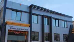 A modern building with a sign reading "MANECK RESIDENCY".