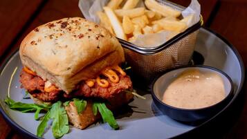 A plate with a chicken sandwich, fries, and a side of sauce.