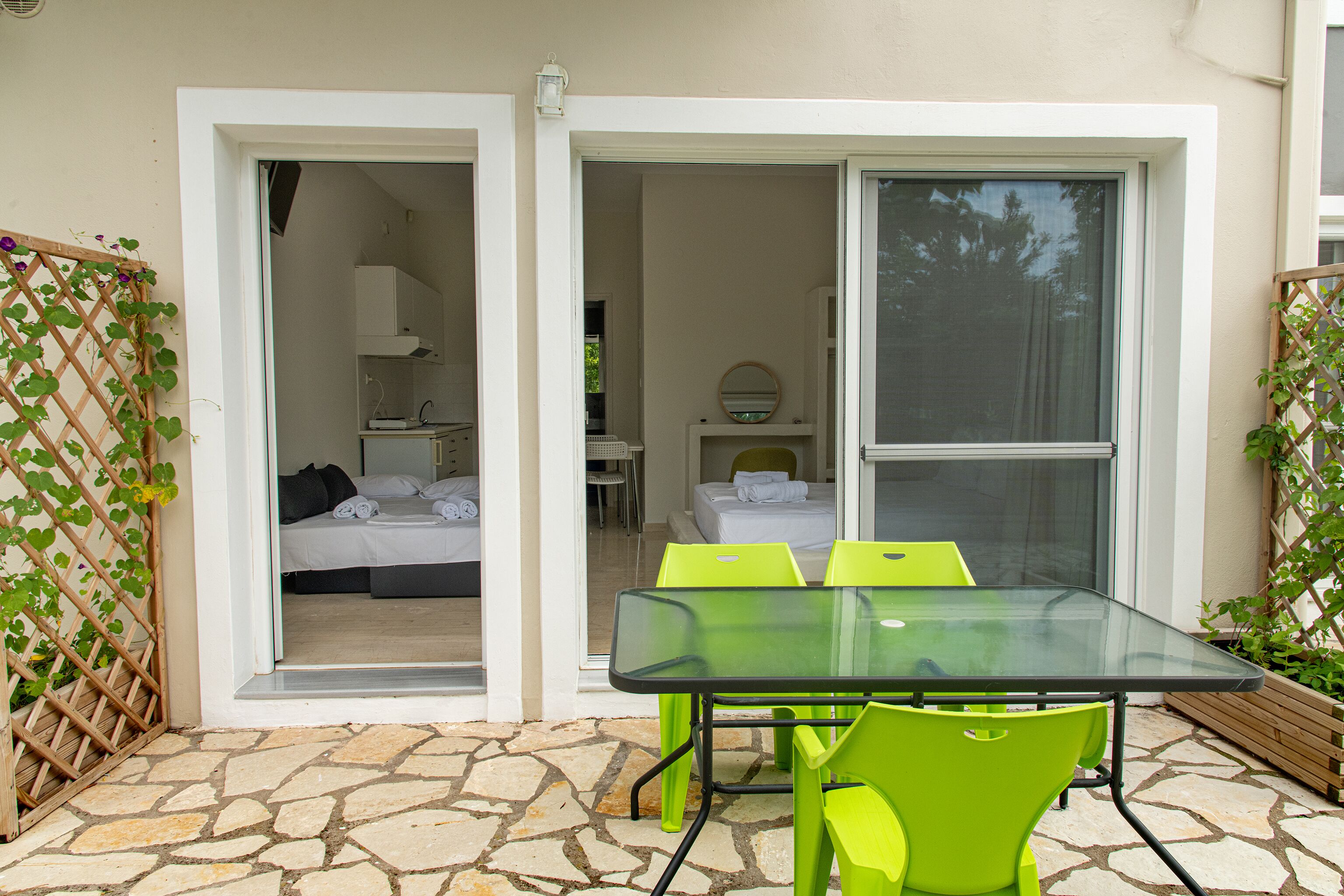 A room with a bed, a table with chairs, and a window.