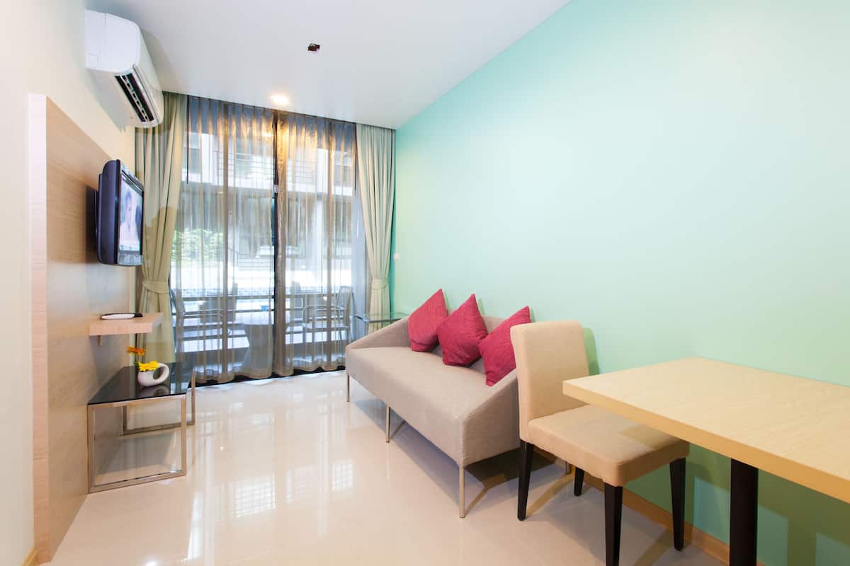 A modern room with a sofa, a table, and a TV mounted on the wall.