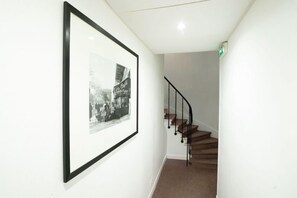 A staircase with a black railing and a framed black and white photograph on the wall. - Hotel Edgar Quinet (Paris)