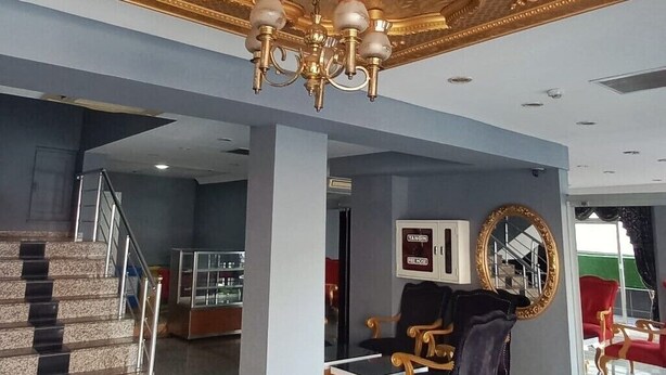 Un vestíbul imponent amb una escalinata de marbre, un penjallum i decorations ornamentals al sostre.