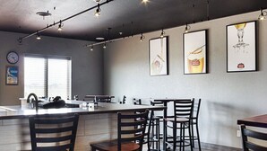 A modern kitchen with a central island, bar stools, and pendant lighting.
