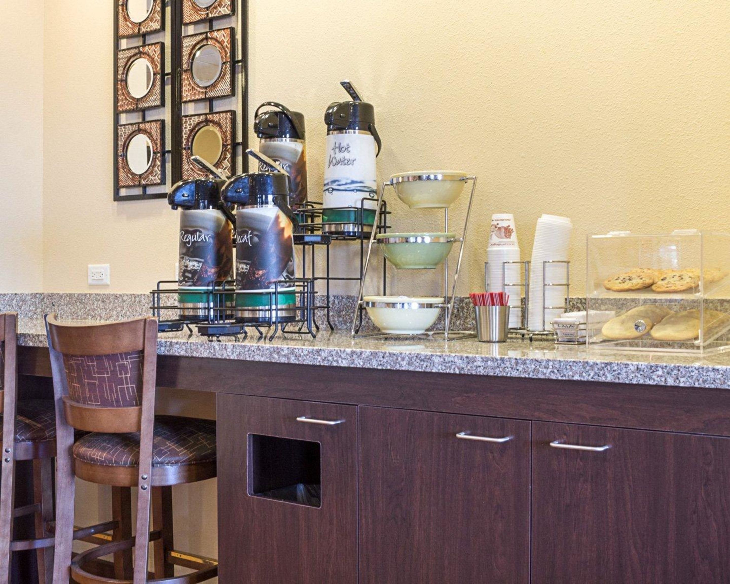 Une cuisine dotée d’un comptoir en granit, d’appareils électroménagers en acier inoxydable et d’un espace dédié à la préparation du café.