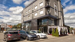 A modern hotel with a flat roof, large windows, and a balcony. There are cars parked in front. - Dash Hotel (Novi Sad)