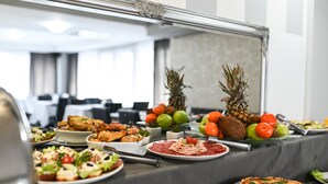 A buffet table with various dishes, including salads, meats, and fruits, in a modern hotel setting. - Dash Hotel (Novi Sad)