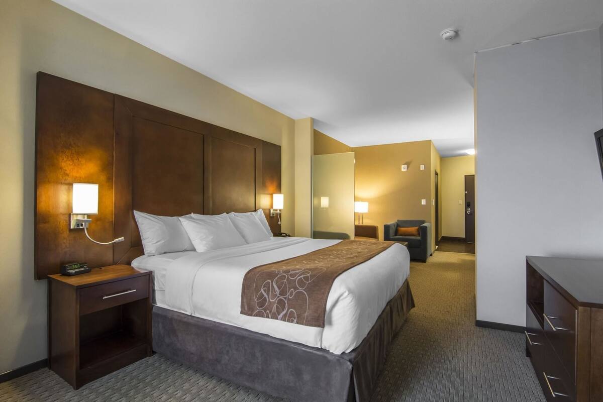 A hotel room with a large bed, bedside tables, a desk, and a chair.