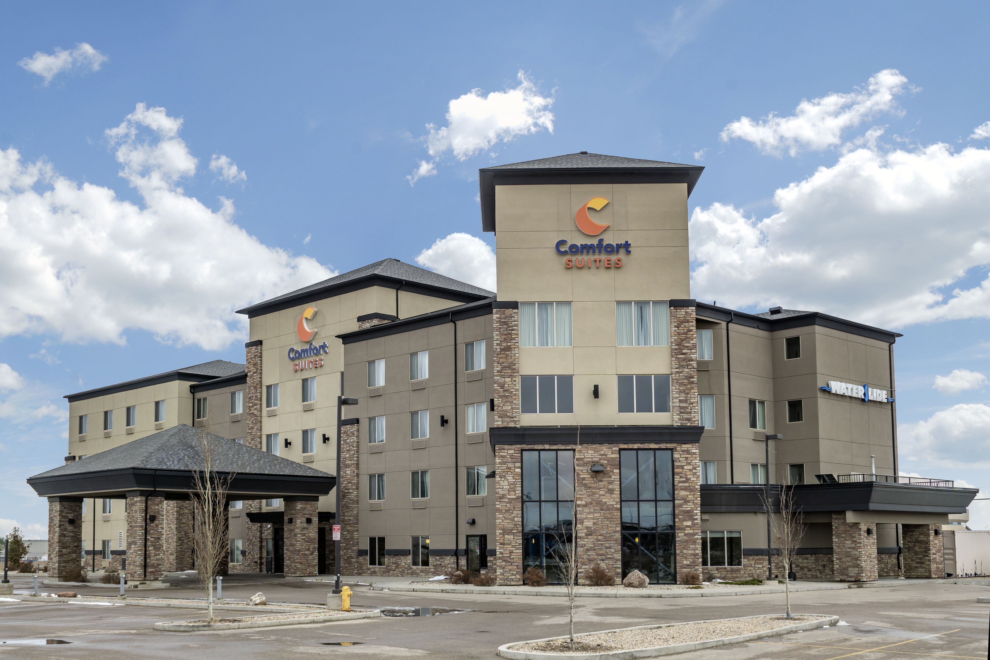 A Comfort Suites hotel with a modern design, featuring a prominent entrance and multiple floors.