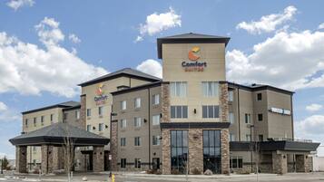 A Comfort Suites hotel with a modern design, featuring a prominent entrance and multiple floors.