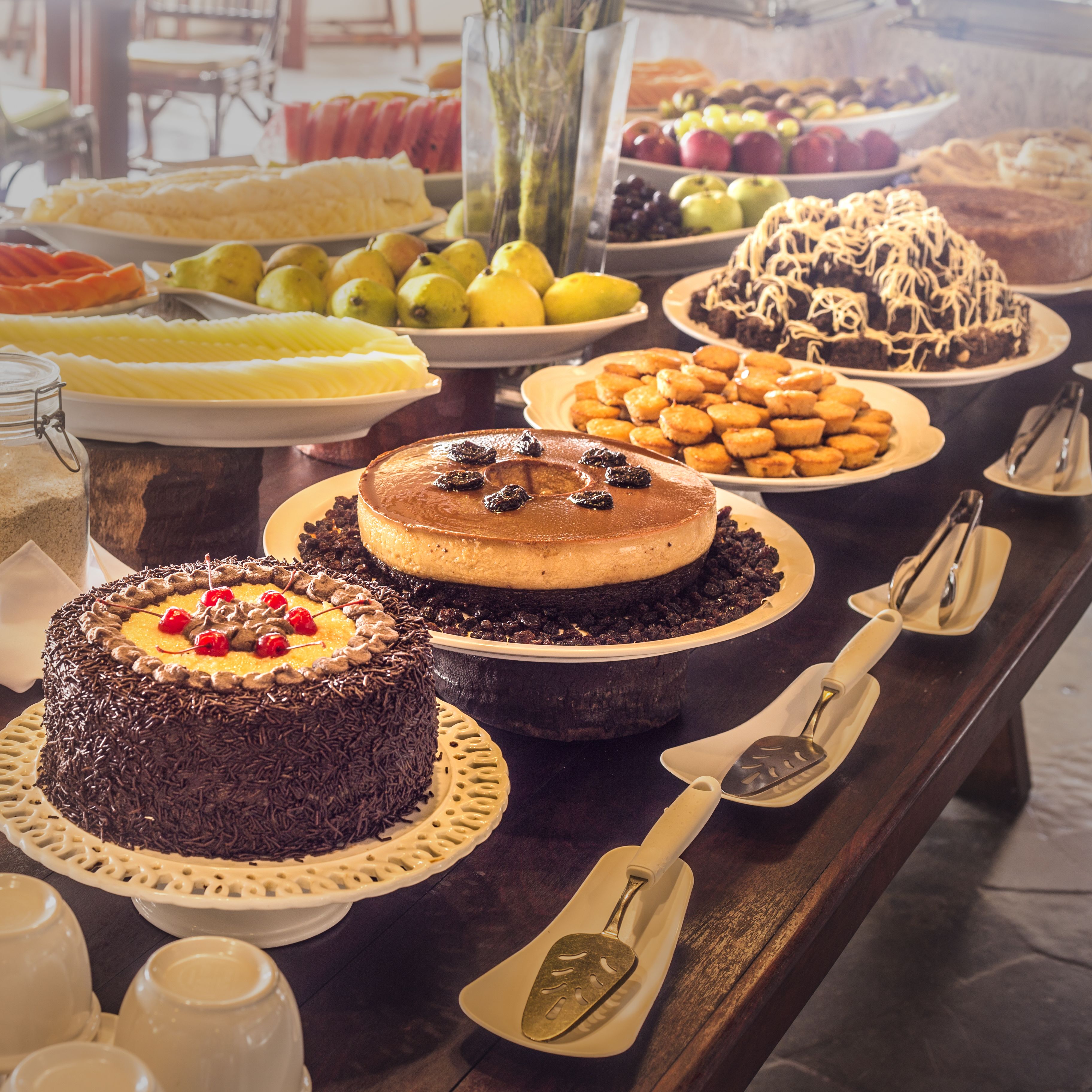 A buffet table with various desserts including cakes and pastries.