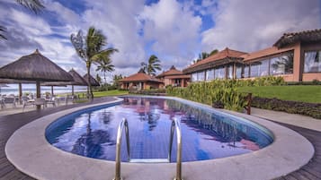 Een buitenzwembad, parasols voor strand/zwembad