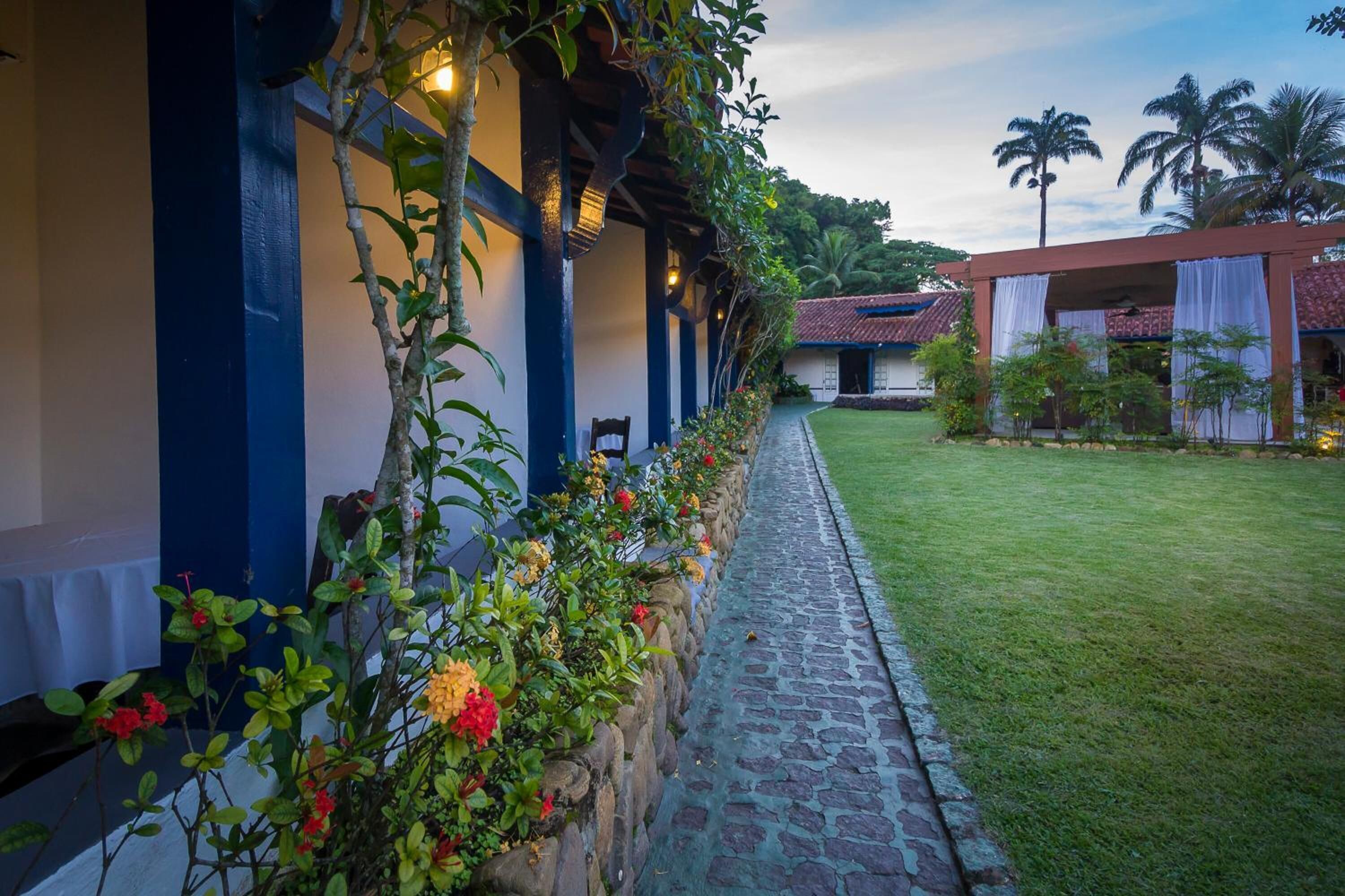Un espacio al aire libre cubierto con un sendero de piedra que conduce a un edificio con tejado de azulejos.