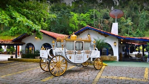 A traditional carriage parked in front of a building with a red-tiled roof and white walls. - Pousada Da Condessa (Paraty)