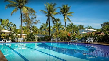 Una piscina al aire libre, sillones reclinables de piscina