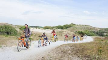 Un grupo de personas pedaleando por un sendero de tierra rodeado de vegetación.
