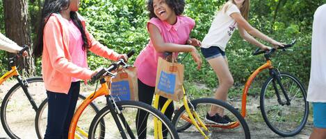 A group of people standing around bicycles in a natural setting.