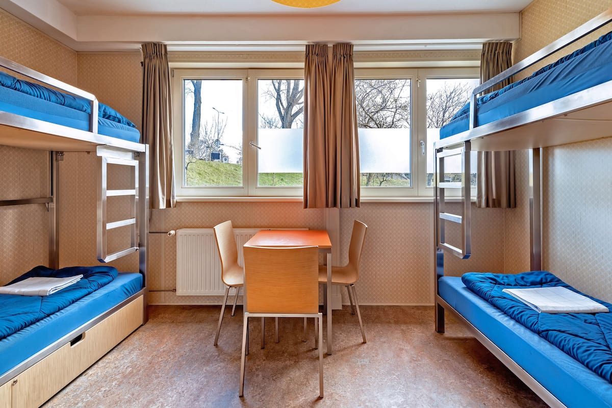 Ein Schlafraum mit zwei Betten, einem Tisch und Stühlen.