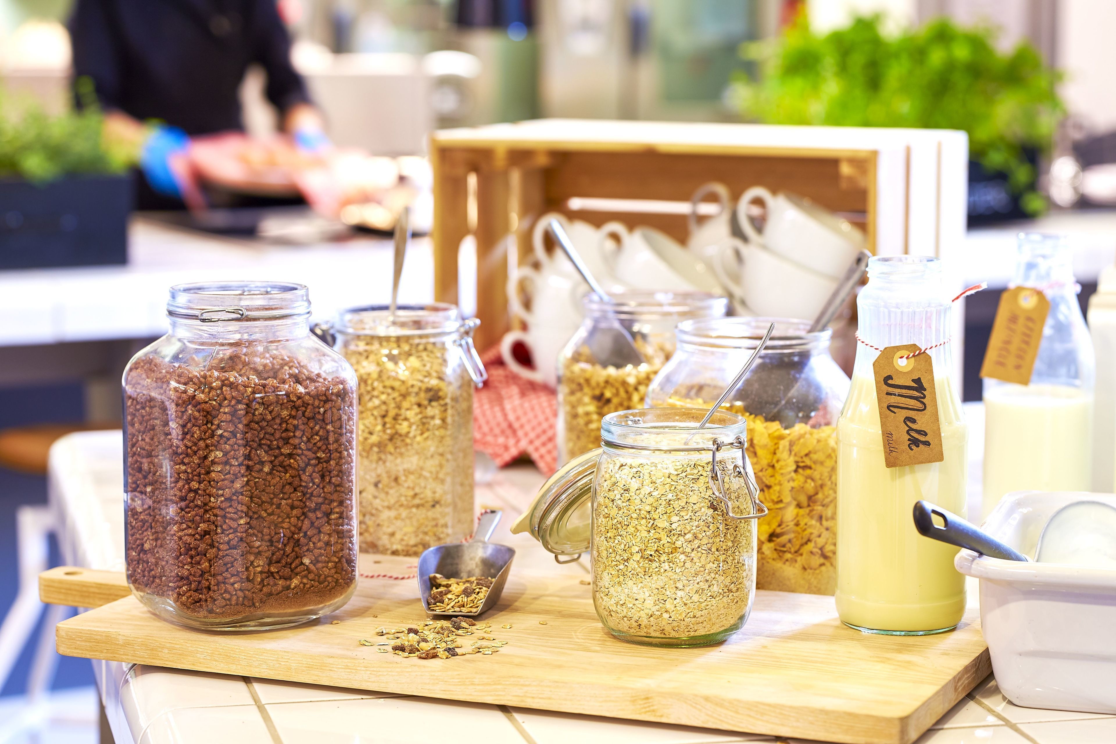 A variety of food items in jars and containers on a wooden table.