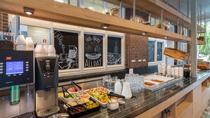 A buffet area with a coffee machine, various food items, and a chalkboard with motivational quotes. - Stayokay Soest - Hostel (Soest)