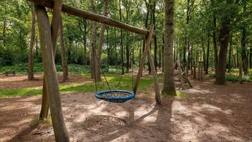 Enjoy a traditional play area with a rustic swing set amidst a serene forest.