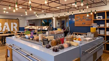 A breakfast bar with various food items and a sign that reads "Life is good but life is better."