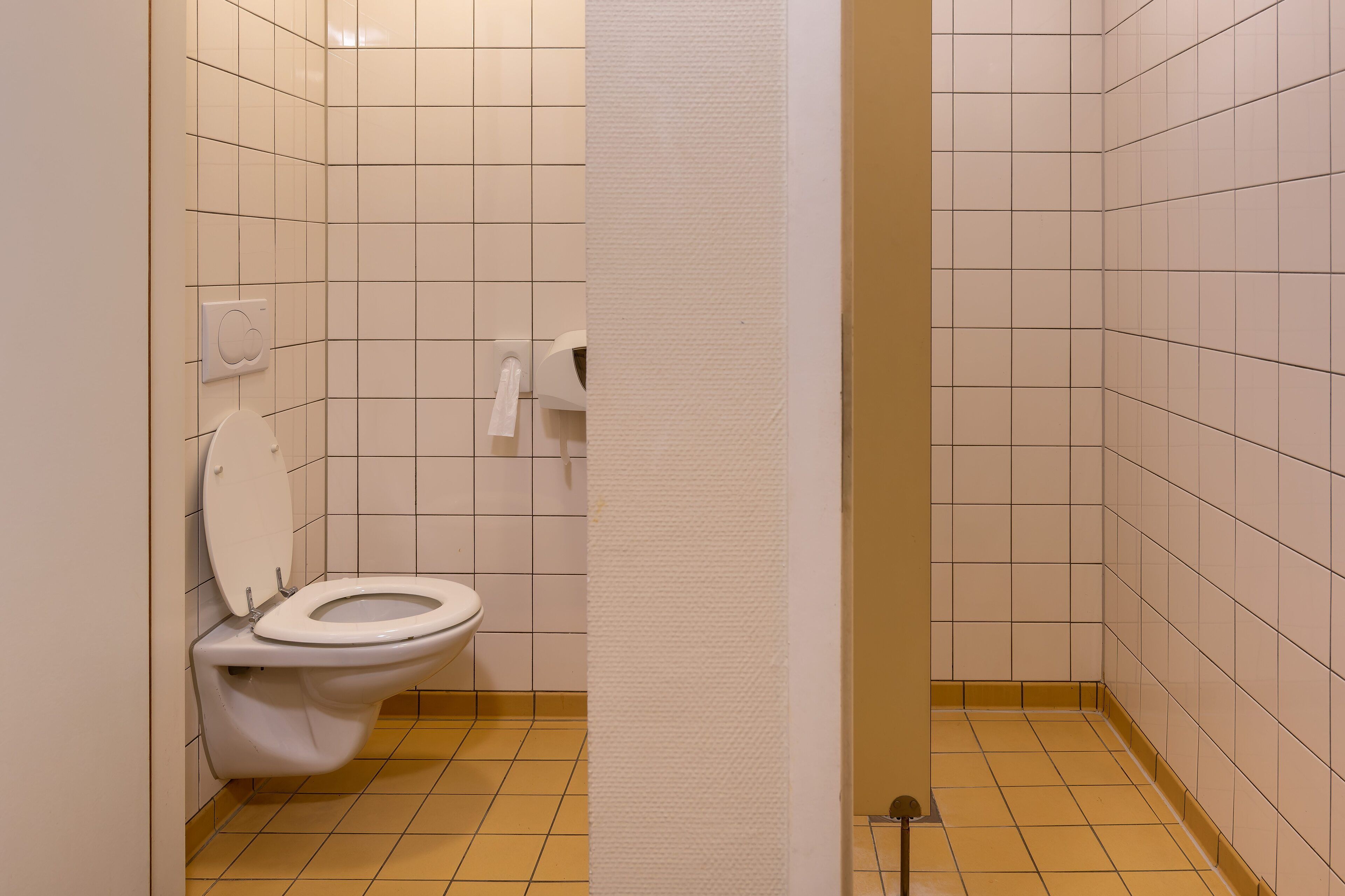 Un baño pequeño con un inodoro, un dispensador de toallas y un dispensador de servilletas de papel.