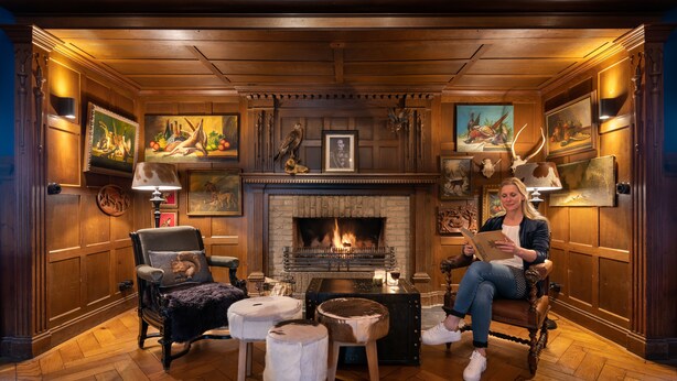 Una habitación acogedora con chimenea, muebles de madera y obras de arte en las paredes.