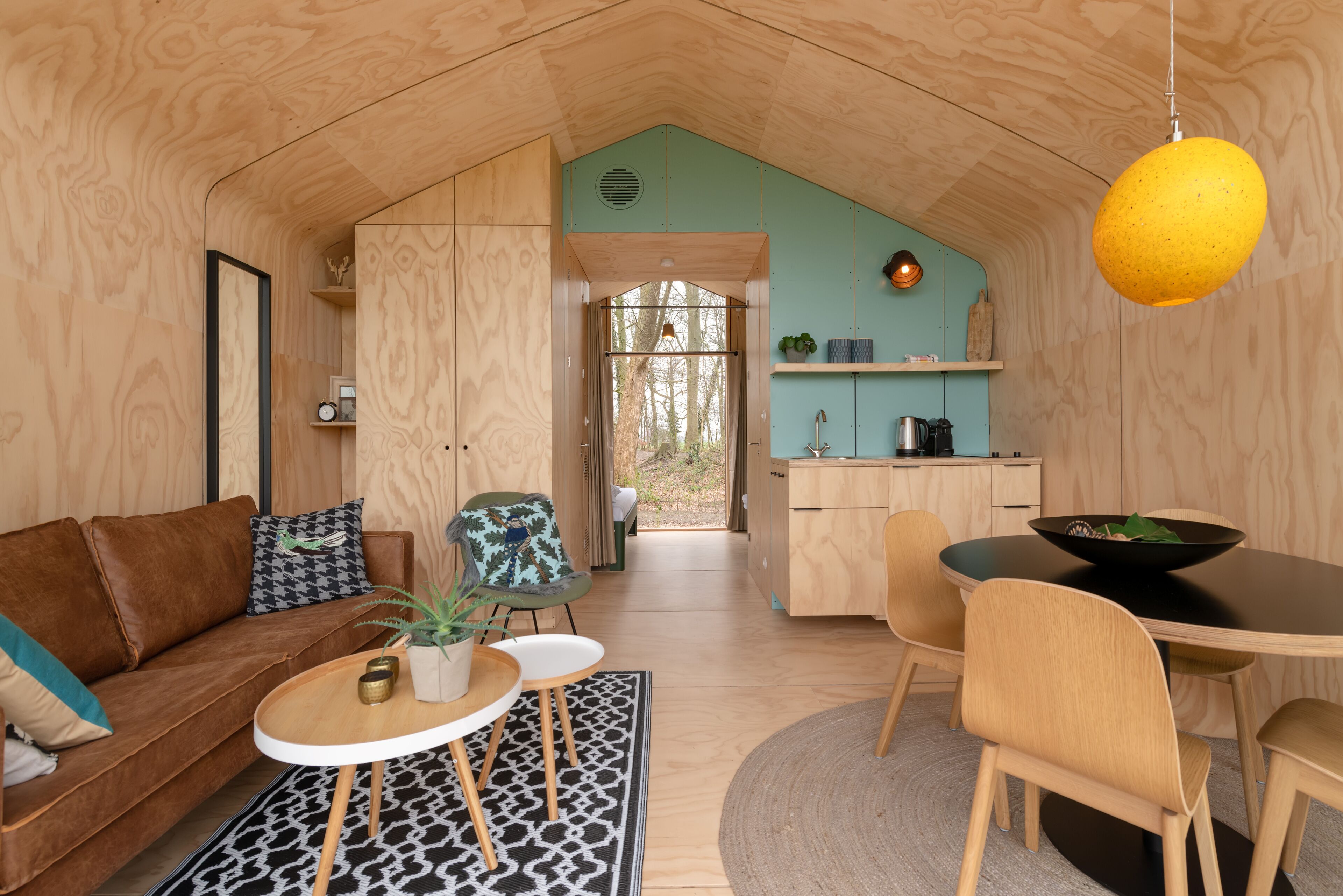 A cozy cabin interior with a living area, a dining table, and a kitchen.