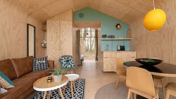 A cozy cabin interior with a living area, a dining table, and a kitchen.