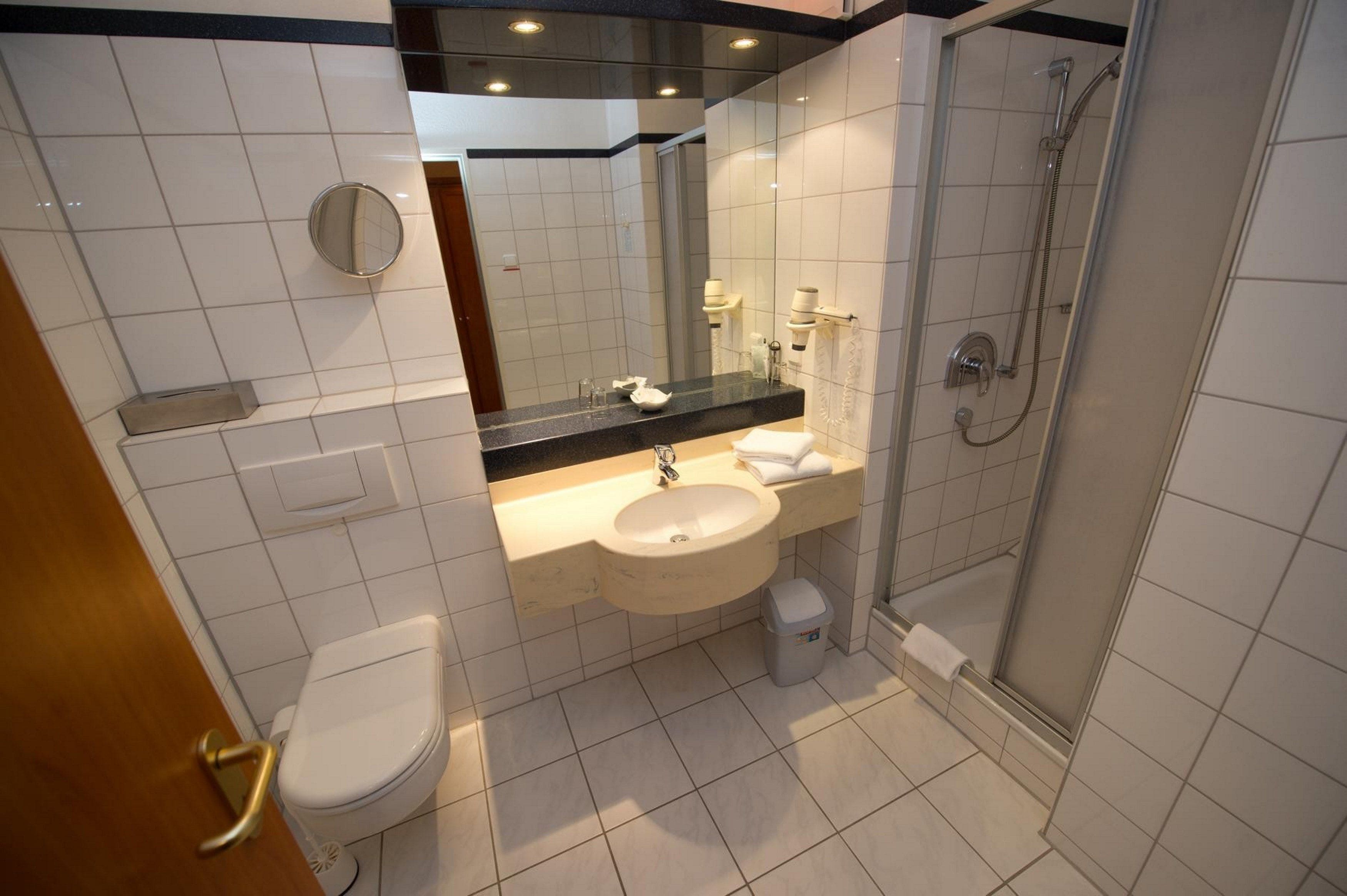 Een moderne badkamer met toilet, wastafel en douche.