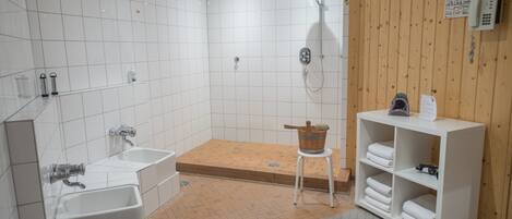 Un baño moderno con bañera, ducha y pared de paneles de madera.