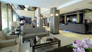 A spacious lobby with a reception desk, a sofa, and a coffee table. - Kaya Prestige (Izmir)