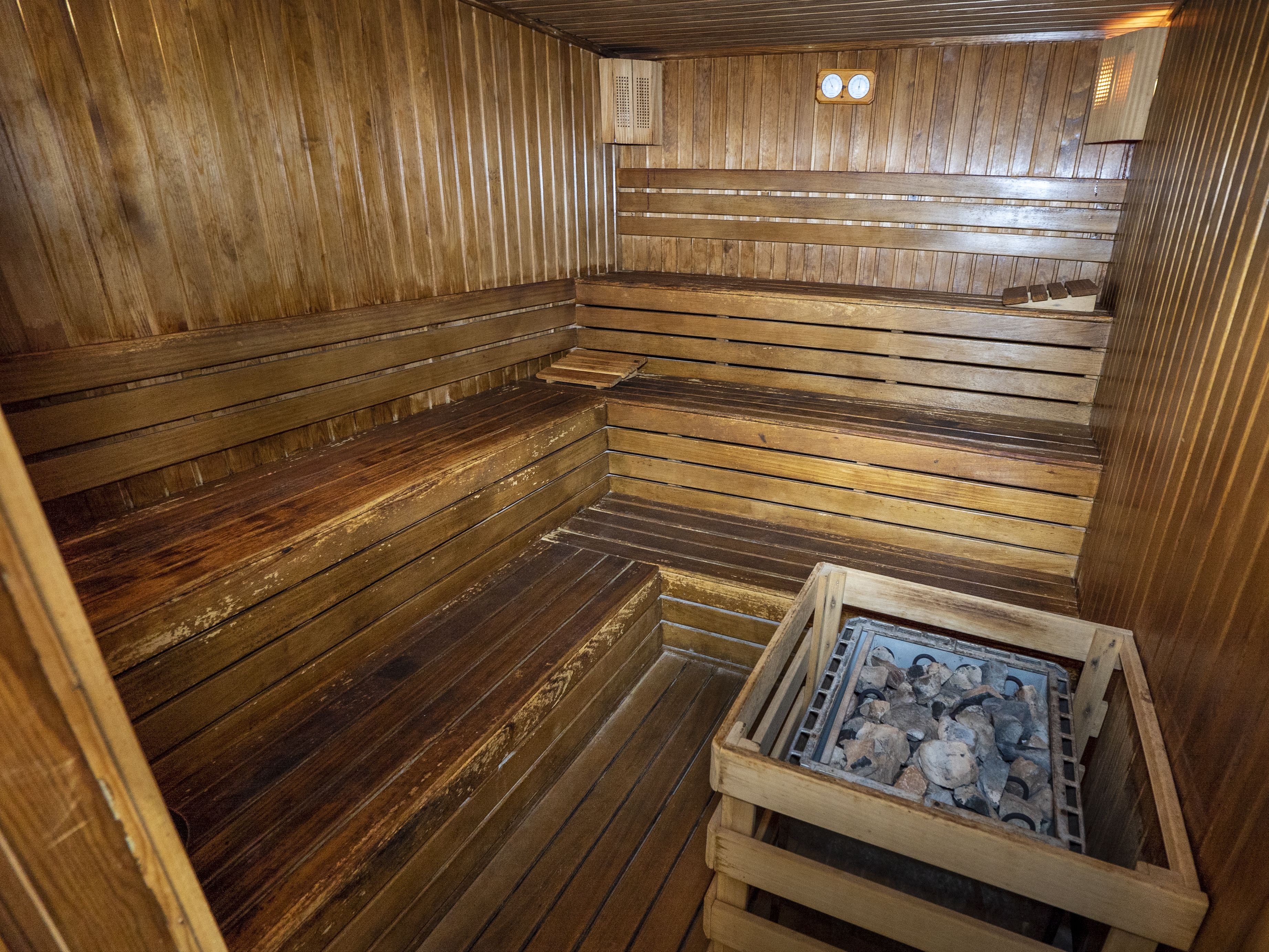 A sauna with wooden benches and a visible heating element.