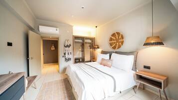 Ein Schlafzimmer mit Bett, Nachttisch, Kleiderschrank und einer Pendelleuchte.