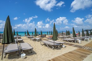 A beach with sun loungers and umbrellas, a wooden deck, and a clear view of the ocean. - Ananea Kleopatra Beach (+12 Adults Only) (Alanya)